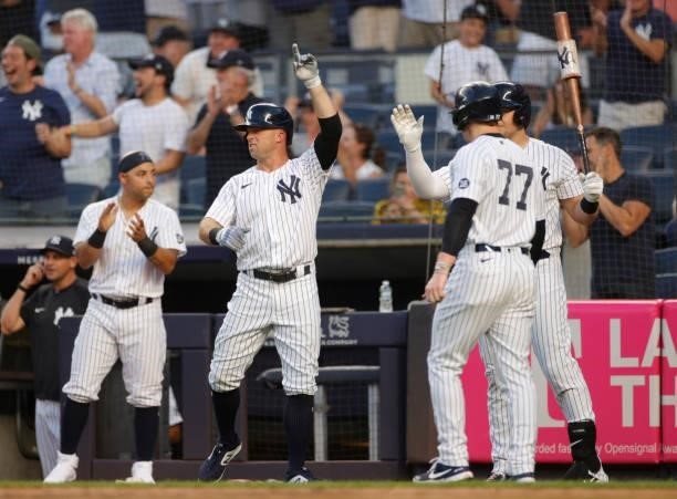 Brett Gardner of the New York Yankees reacts as he, Gleyber Torres , and Clint Frazier score off of a 3-RBI double hit by DJ LeMahieu during the...