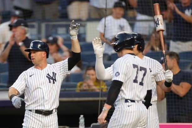 Brett Gardner of the New York Yankees reacts as he, Gleyber Torres , and Clint Frazier score off of a 3-RBI double hit by DJ LeMahieu during the...