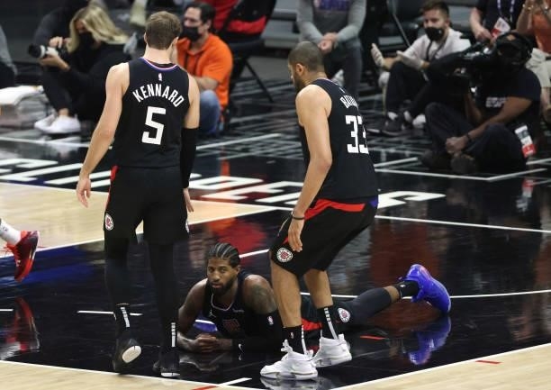 Paul George of the LA Clippers reacts as he falls to the court under Luke Kennard and Nicolas Batum during the first half in Game Six of the Western...