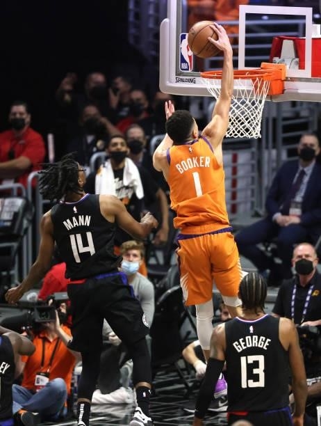 Devin Booker of the Phoenix Suns dunks against Terance Mann of the LA Clippers during the second half in Game Six of the Western Conference Finals at...