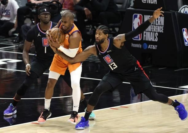Chris Paul of the Phoenix Suns protects the ball against Reggie Jackson and Paul George of the LA Clippers during the second half in Game Six of the...