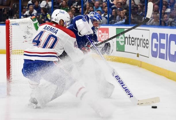 Goaltender Andrei Vasilevskiy of the Tampa Bay Lightning beats Joel Armia of the Montreal Canadiens to the puck behind the net during the second...