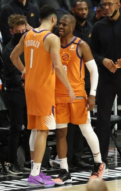 Chris Paul and Devin Booker of the Phoenix Suns hug in the final seconds of the team's win against the LA Clippers during the second half in Game Six...