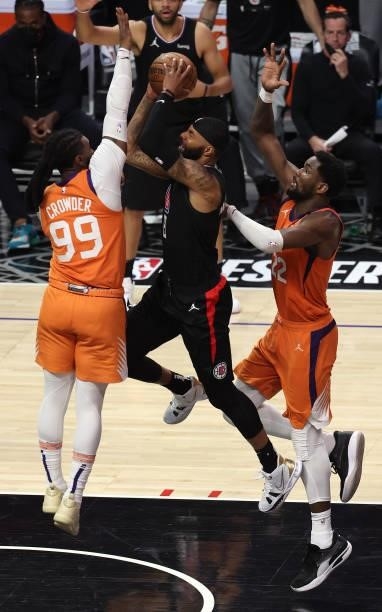 Marcus Morris Sr. #8 of the LA Clippers is defended by Jae Crowder and Deandre Ayton of the Phoenix Suns during the second half in Game Six of the...