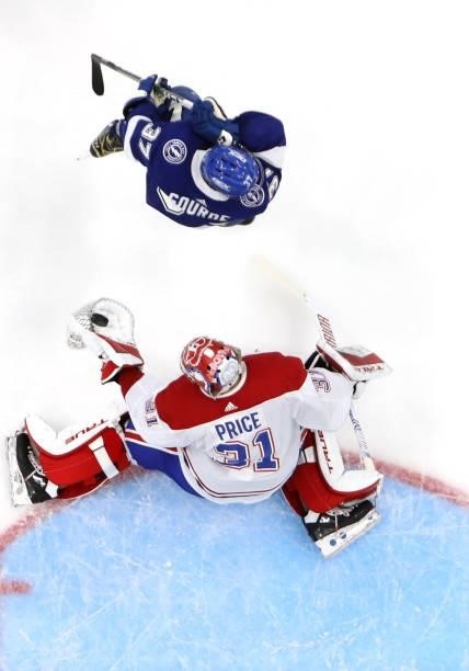 Carey Price of the Montreal Canadiens makes a save behind Yanni Gourde of the Tampa Bay Lightning during the second period of Game Two of the 2021...
