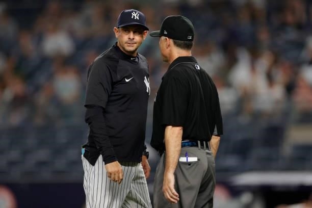 Manager Aaron Boone of the New York Yankees talks with umpire Dan Iassogna during the ninth inning against the Los Angeles Angels at Yankee Stadium...