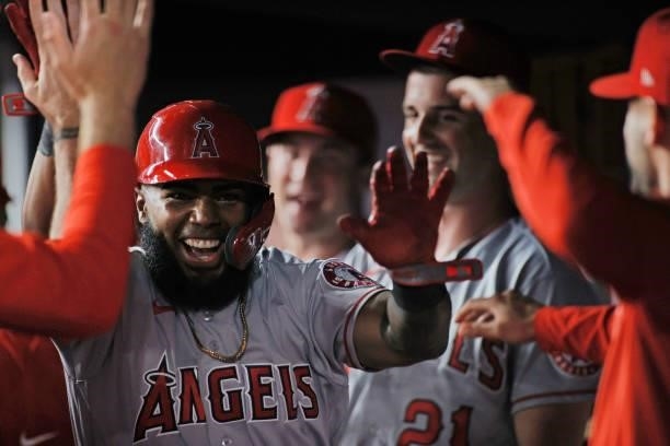 Luis Rengifo of the Los Angeles Angels high-fives teammates in the dugout after scoring off of a RBI double hit by Taylor Ward during the ninth...