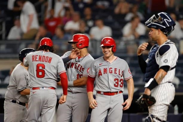 Anthony Rendon, Juan Lagares, and Max Stassi of the Los Angeles Angels celebrate after scoring on a grand slam to tied the game hit by Jared Walsh as...