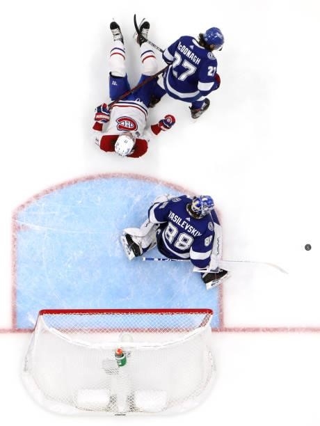 Josh Anderson of the Montreal Canadiens goes down between Ryan McDonagh and goaltender Andrei Vasilevskiy of the Tampa Bay Lightning during the...