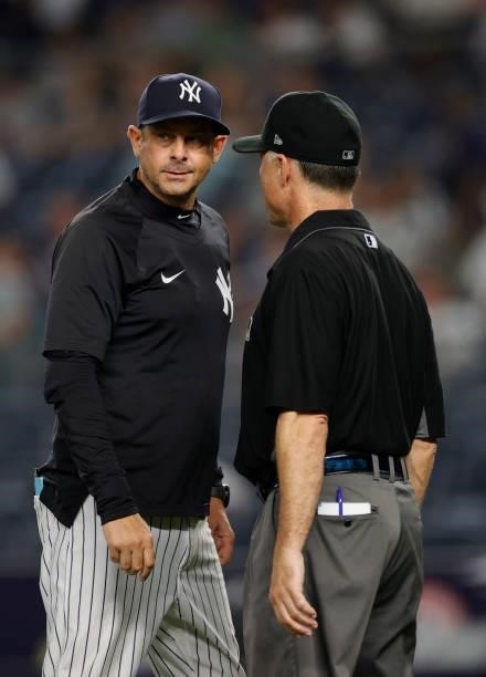 Manager Aaron Boone of the New York Yankees talks with umpire Dan Iassogna during the ninth inning against the Los Angeles Angels at Yankee Stadium...