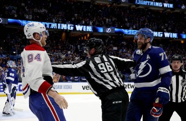 Corey Perry of the Montreal Canadiens is separated by linesman David Brisebois from Victor Hedman of the Tampa Bay Lightning during the third period...