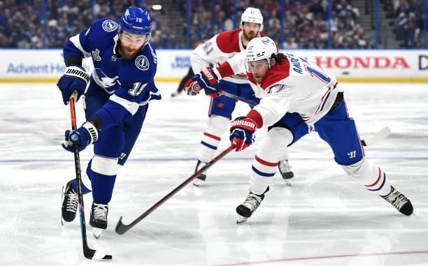Josh Anderson of the Montreal Canadiens reaches for the puck from Barclay Goodrow of the Tampa Bay Lightning during the second period of Game Two of...