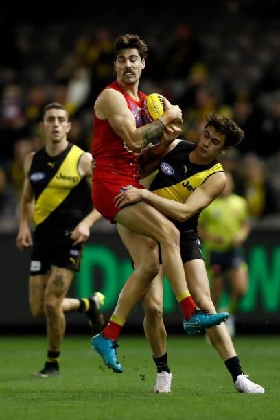 Alex Sexton of the Suns gathers the ball as Patrick Naish of the Tigers applies pressure during the round 16 AFL match between the Gold Coast Suns...