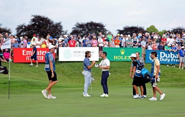 Tommy Fleetwood of England and Rory McIlroy of Northern Ireland shake hands on the 18th hole during Day One of The Dubai Duty Free Irish Open at...