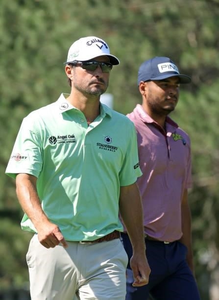 Kevin Kisner and Sebastian Munoz of Colombia walk from the fourth tee during the first round of the Rocket Mortgage Classic on July 01, 2021 at the...