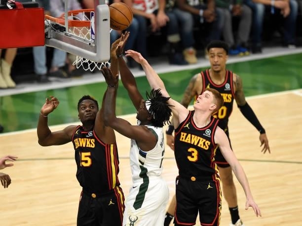 Jrue Holiday of the Milwaukee Bucks goes up for a shot against Clint Capela and Kevin Huerter of the Atlanta Hawks during the first quarter in Game...