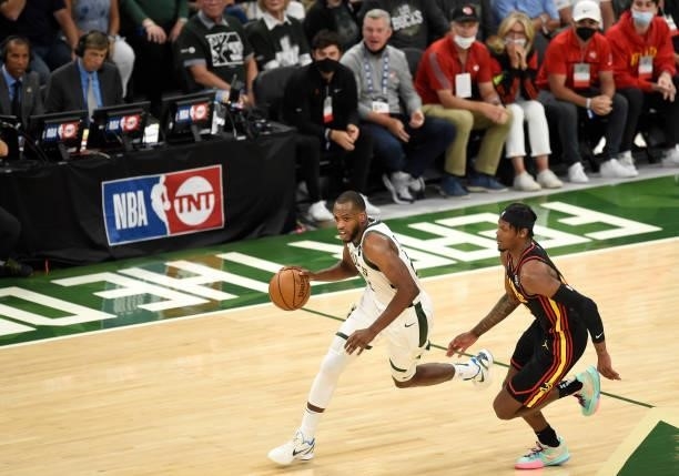 Khris Middleton of the Milwaukee Bucks brings the ball up court against Cam Reddish of the Atlanta Hawks during the first half in Game Five of the...