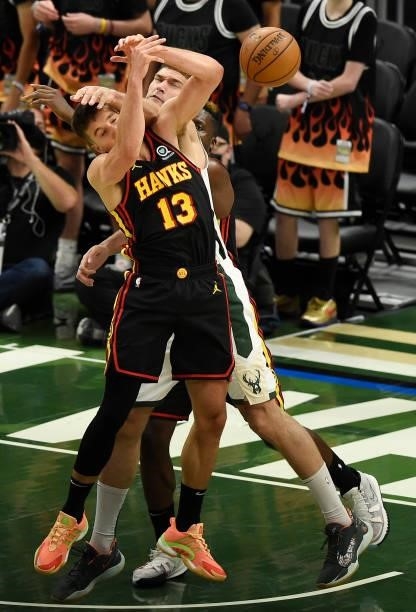 Bogdan Bogdanovic of the Atlanta Hawks and Brook Lopez of the Milwaukee Bucks tangle during the second half in Game Five of the Eastern Conference...