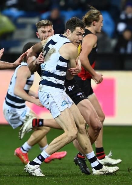 Jeremy Cameron of the Cats is tackled by Jayden Laverde of the Bombers during the round 16 AFL match between Geelong Cats and Essendon Bombers at...