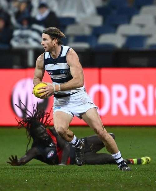 Lachie Henderson of the Cats gathers the ball infront of Anthony McDonald-Tipungwuti of the Bombers during the round 16 AFL match between Geelong...