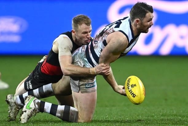 Patrick Dangerfield of the Cats is tackled by Nick Hind of the Bombers during the round 16 AFL match between Geelong Cats and Essendon Bombers at...