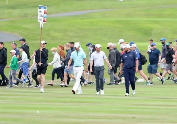 Martin Kaymer of Germany, Jonathan Caldwell of Northern Ireland and Shane Lowry of Ireland walk down the 18th hole during Day Two of The Dubai Duty...
