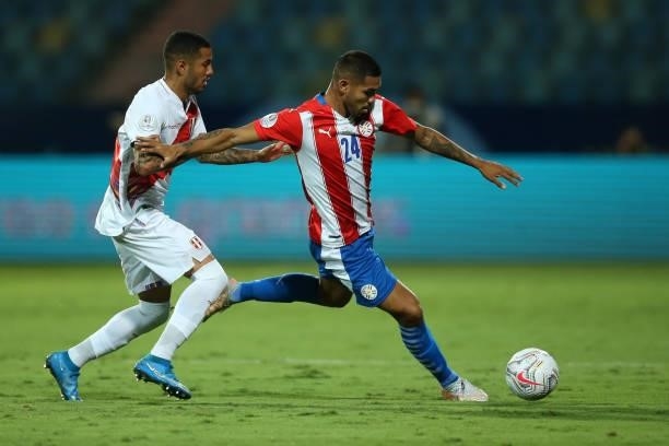 Hector Martinez of Paraguay kicks the ball against Sergio Peña of Peru during a quarterfinal match between Peru and Paraguay as part of Copa America...