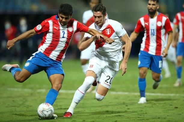 Robert Rojas of Paraguay kicks the ball against Santiago Ormeño of Peru during a quarterfinal match between Peru and Paraguay as part of Copa America...