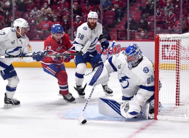 Andrei Vasilevskiy of the Tampa Bay Lightning takes control of the puck as Nick Suzuki of the Montreal Canadiens looks to attack during the first...