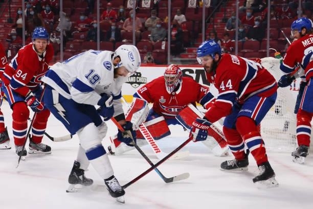 Barclay Goodrow of the Tampa Bay Lightning and Joel Edmundson of the Montreal Canadiens battle for the puck as Carey Price tends net during the first...