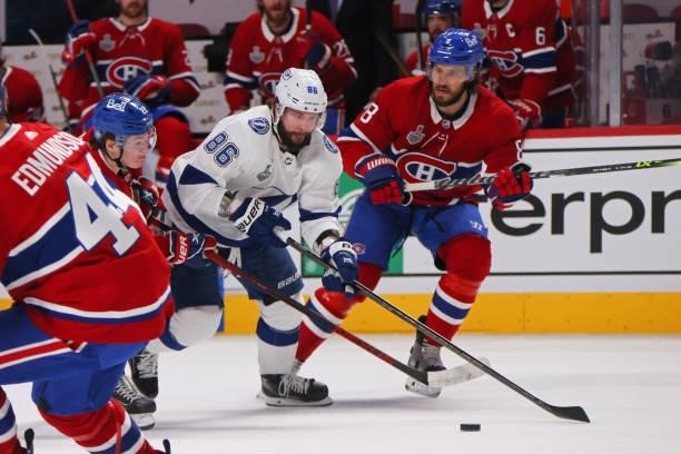 Nikita Kucherov of the Tampa Bay Lightning battles Cole Caufield of the Montreal Canadiens for possession during the first period in Game Three of...
