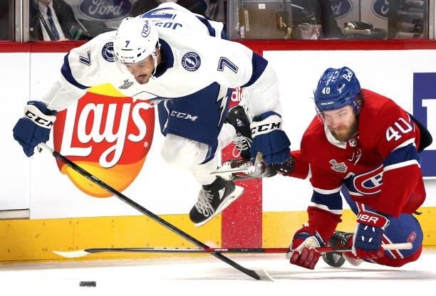 Mathieu Joseph of the Tampa Bay Lightning takes flight after getting tangled up with Joel Armia of the Montreal Canadiens during the first period of...