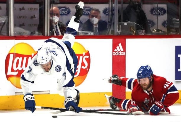 Mathieu Joseph of the Tampa Bay Lightning falls to the ice after getting tangled up with Joel Armia of the Montreal Canadiens during the first period...