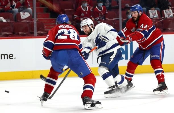 Tyler Johnson of the Tampa Bay Lightning takes a shot between Jon Merrill and Joel Edmundson of the Montreal Canadiens during the first period of...