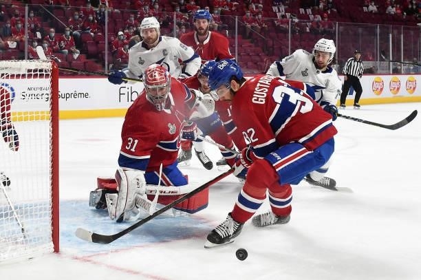 Erik Gustafsson of the Montreal Canadiens looks to the puck as Carey Price tends goal against Steven Stamkos and Anthony Cirelli of the Tampa Bay...