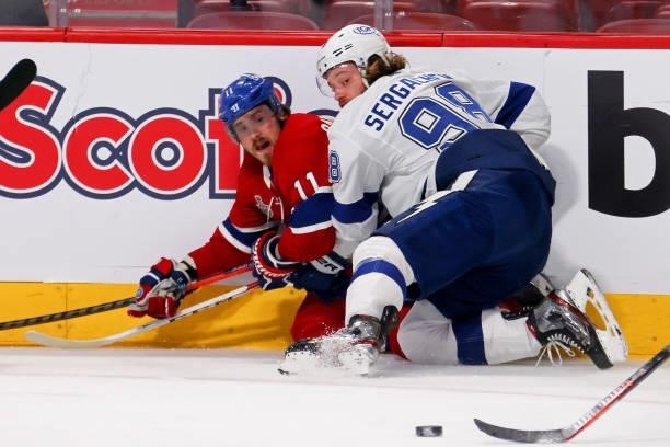 Brendan Gallagher of the Montreal Canadiens and Mikhail Sergachev of the Tampa Bay Lightning watch the puck after colliding during the second period...