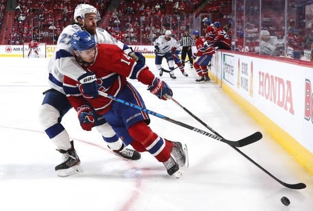 Ryan McDonagh of the Tampa Bay Lightning and Nick Suzuki of the Montreal Canadiens compete for the puck in the corner during the second period of...