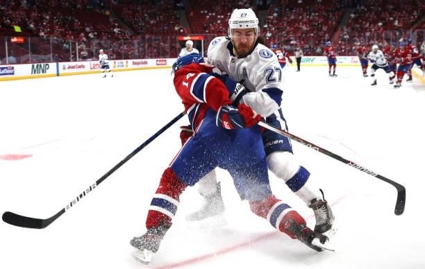 Ryan McDonagh of the Tampa Bay Lightning and Nick Suzuki of the Montreal Canadiens collide in the corner during the second period of Game Three of...