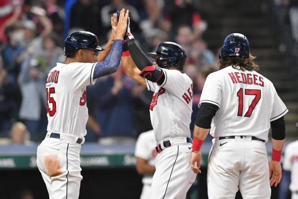 Oscar Mercado of the Cleveland Indians celebrates with Cesar Hernandez and Austin Hedges after all three scored on a home run by Hernandez during the...