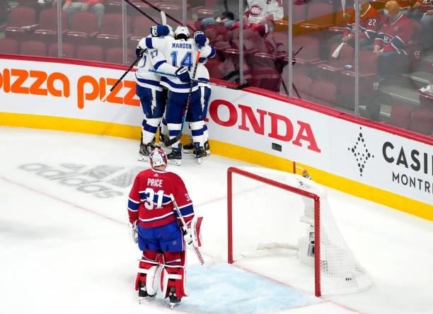 Carey Price of the Montreal Canadiens looks on as Tyler Johnson of the Tampa Bay Lightning celebrates with teammates after scoring during the third...