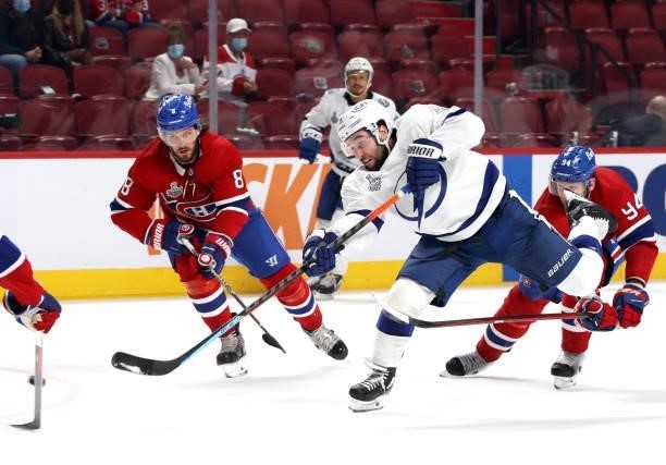 Tyler Johnson of the Tampa Bay Lightning takes a shot between Ben Chiarot and Corey Perry of the Montreal Canadiens during the third period of Game...