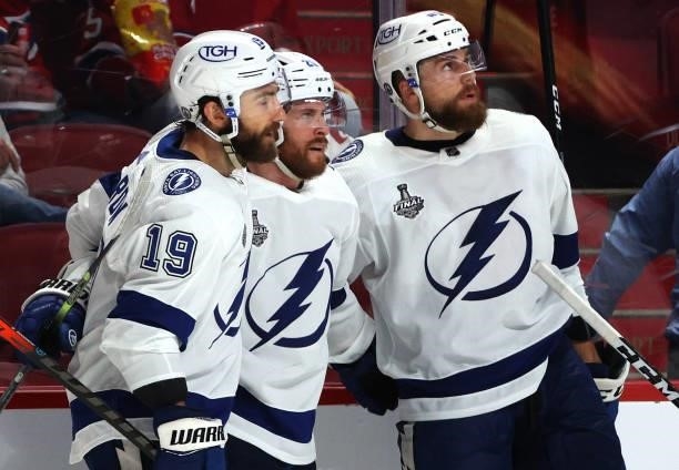 Blake Coleman of the Tampa Bay Lightning celebrates his empty net goal against the Montreal Canadiens with teammates Barclay Goodrow and Yanni Gourde...