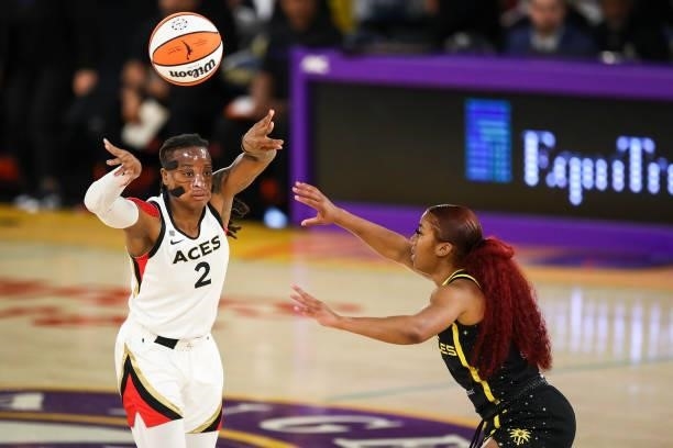 Guard Riquna Williams of the Las Vegas Aces passes the ball over guard Te'a Cooper of the Los Angeles Sparks at Los Angeles Convention Center on July...