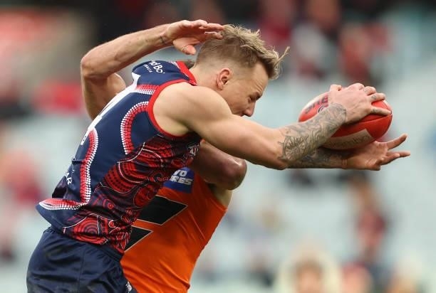 James Harmes of the Demons is challenged by Sam J. Reid of the Giants during the round 16 AFL match between Melbourne Demons and Greater Western...
