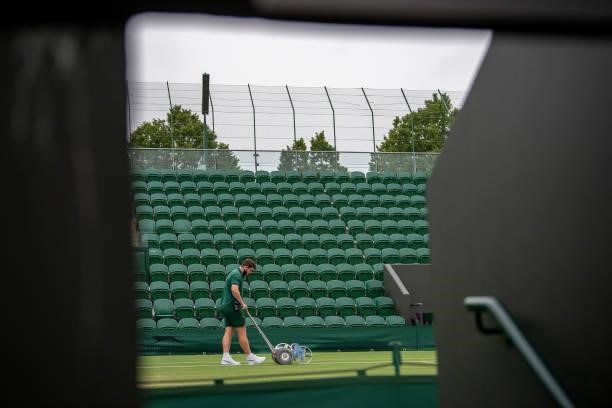 Ground Staff mark the white lines on No.3 Court during Day Six of The Championships - Wimbledon 2021 at All England Lawn Tennis and Croquet Club on...