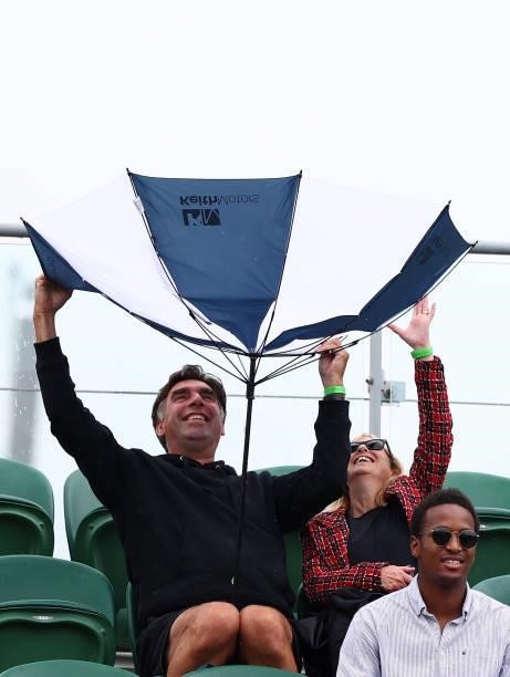 Spectators are seen with umbrella's as rain delays play on Day Six of The Championships - Wimbledon 2021 at All England Lawn Tennis and Croquet Club...