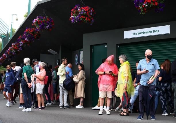 Fans shelter underneath the stands as rain delays play on Day Six of The Championships - Wimbledon 2021 at All England Lawn Tennis and Croquet Club...