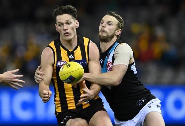 Jacob Koschitzke of the Hawks handballs whilst being tackled during the round 16 AFL match between Hawthorn Hawks and Port Adelaide Power at Marvel...