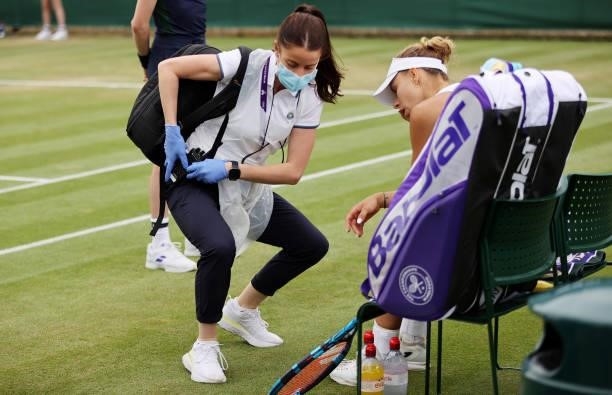 Magda Linette of Poland receives treatment during her Ladies' Singles third Round match against Paula Badosa of Spain during Day Six of The...