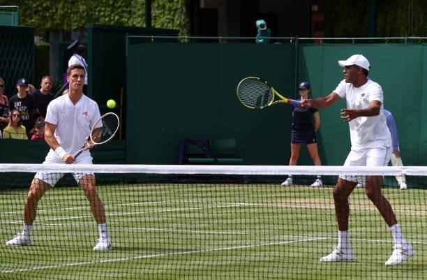 Rajeev Ram of United States plays a forehand watched on by partner Joe Salisbury of Great Britain during their men's doubles second round match...
